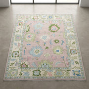 Overhead view of a light pink Oushak rug highlighting pattern integrity and luxurious weave with natural lighting.