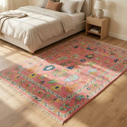 High-resolution image of the Pink Hand Knotted Rug in a stylish bedroom, emphasizing its texture and integration into the room's decor.
