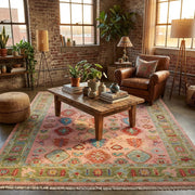 Artistic scene of pink Turkish Oushak rug in a bohemian loft, styled with eclectic decor, vintage furniture, and warm golden-hour lighting.